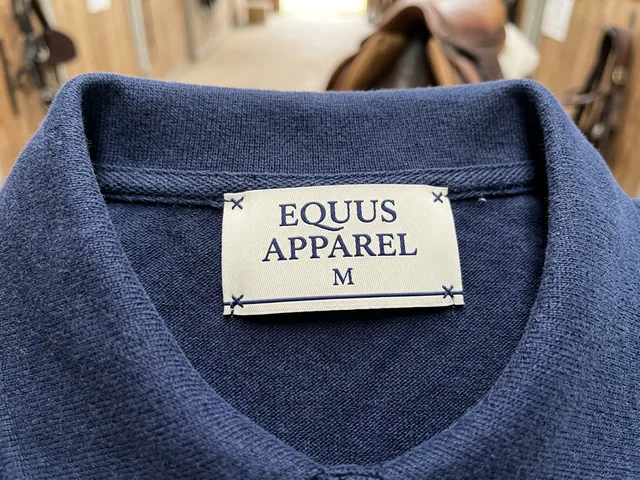 Etiqueta de cuello con la marca de la tienda en un polo de equitación